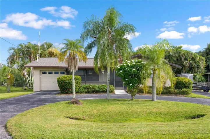 Single-story residence featuring an attached garage, screened porch, and a paved driveway