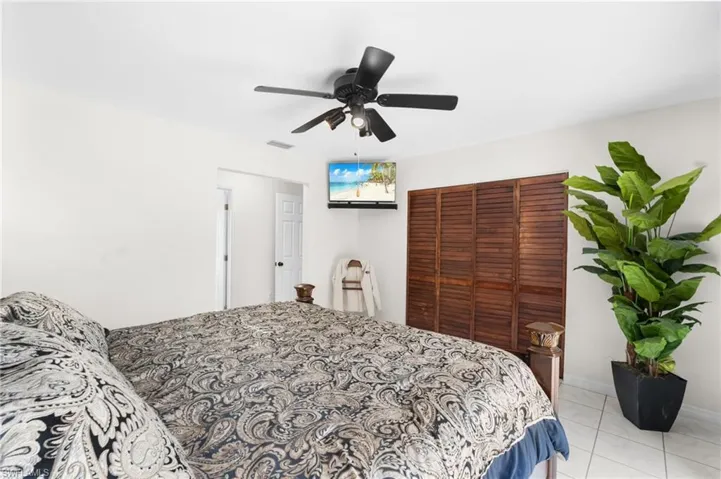 White tile flooring, white walls, and a ceiling fan