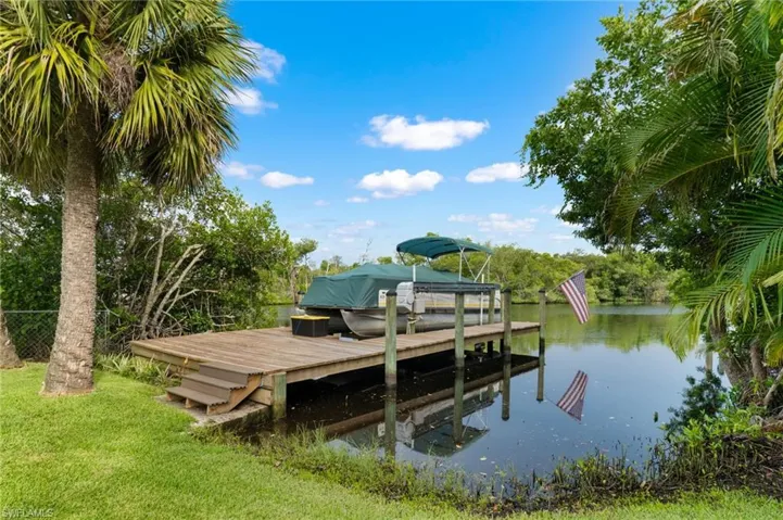 Expansive waterfront with a wooden boat dock and boat lift