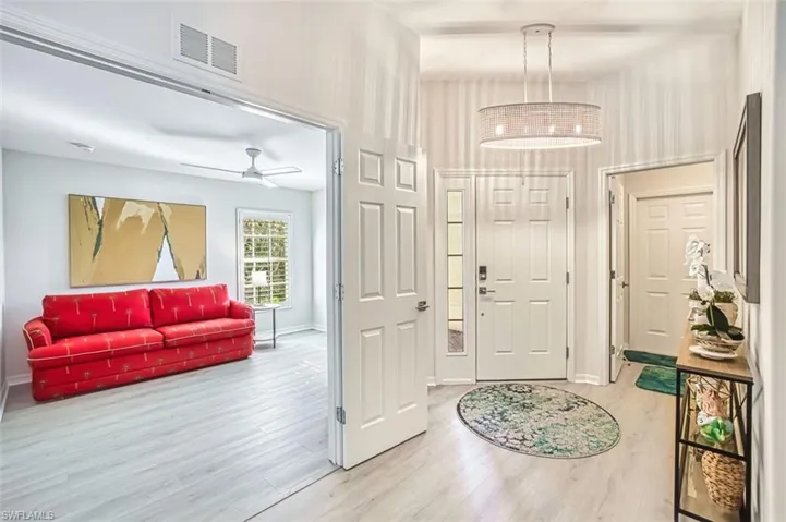 Entrance foyer with light wood-style flooring and a ceiling fan