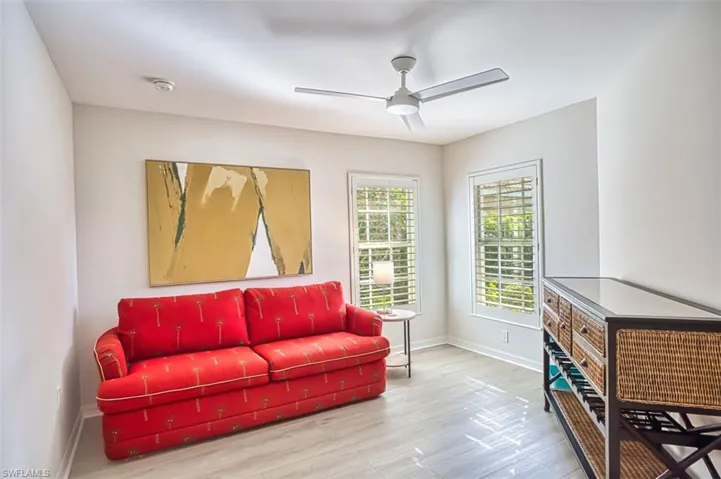 Living area with light wood-style floors and ceiling fan