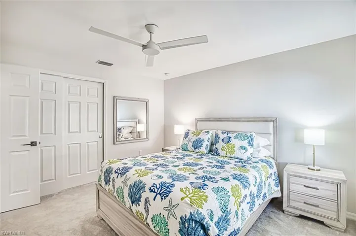 Bedroom featuring a closet, light carpet, and a ceiling fan