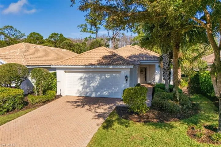 View of front of property with decorative driveway, an attached garage, stucco siding, and a tiled roof