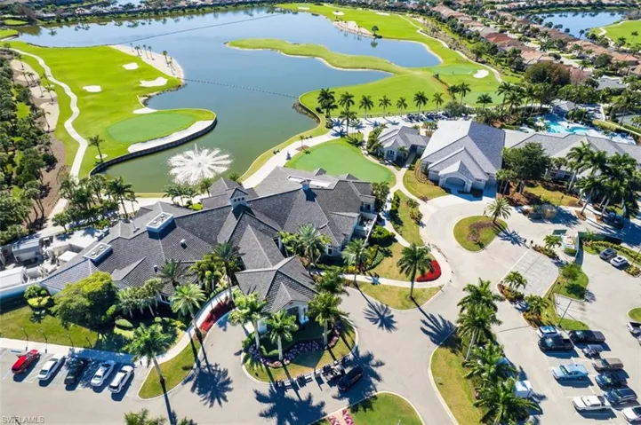 Aerial perspective of suburban area featuring a local golf course and a nearby body of water