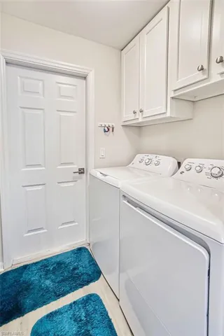 Laundry area featuring separate washer and dryer and cabinet space