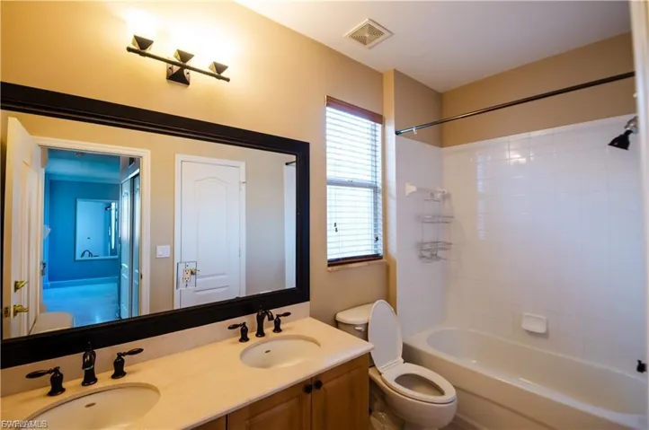 Bathroom featuring double vanity and bathtub / shower combination