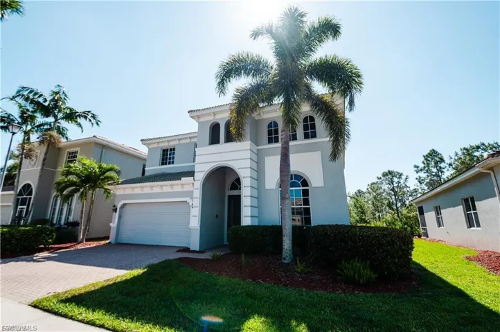Mediterranean / spanish-style house with decorative driveway, stucco siding, a front yard, and a tiled roof