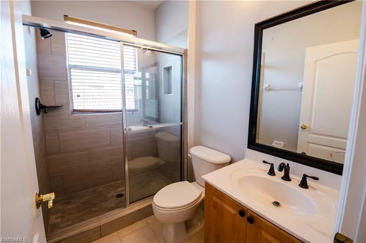 Bathroom with vanity, a stall shower, and light tile patterned floors