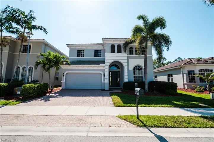 Mediterranean / spanish home with decorative driveway, stucco siding, a front lawn, and an attached garage