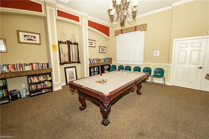 Playroom with ornamental molding, pool table, and a chandelier
