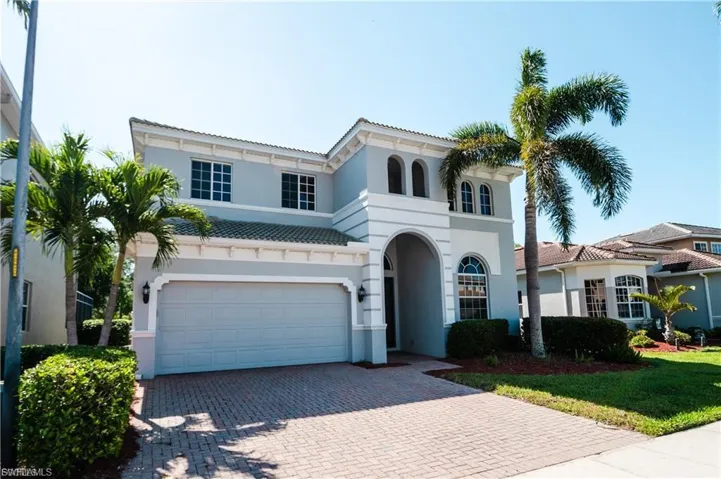 Mediterranean / spanish home featuring decorative driveway, a garage, a tile roof, and stucco siding