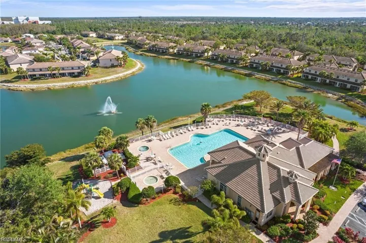 Aerial perspective of suburban area featuring a pool and a large body of water
