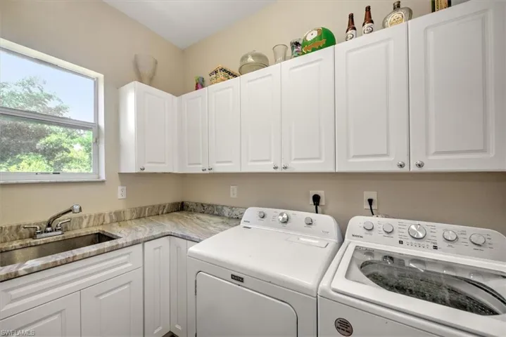 Laundry area featuring cabinets, independent washer and dryer, and sink