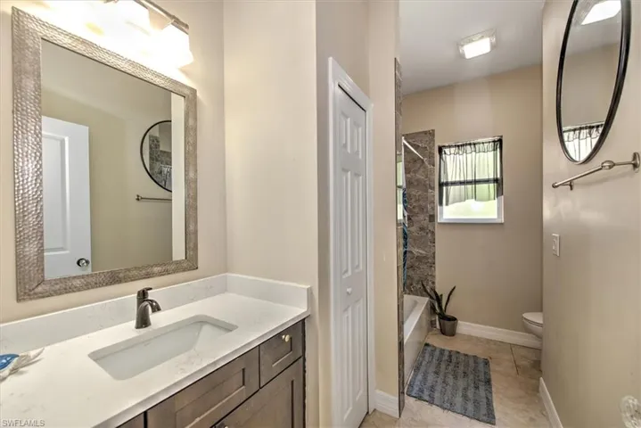 Full bathroom featuring tile patterned flooring, vanity,  shower combination, and toilet