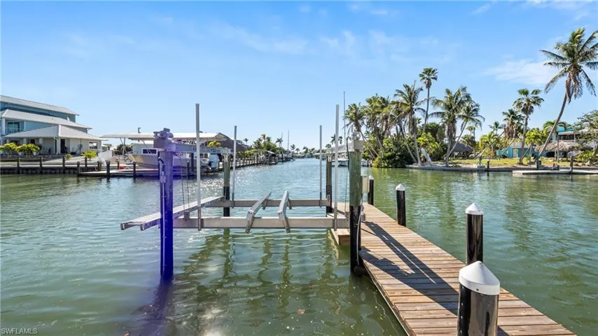 Dock area featuring boat lift and a water view
