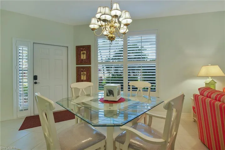 Tiled dining room with plenty of natural light and a chandelier