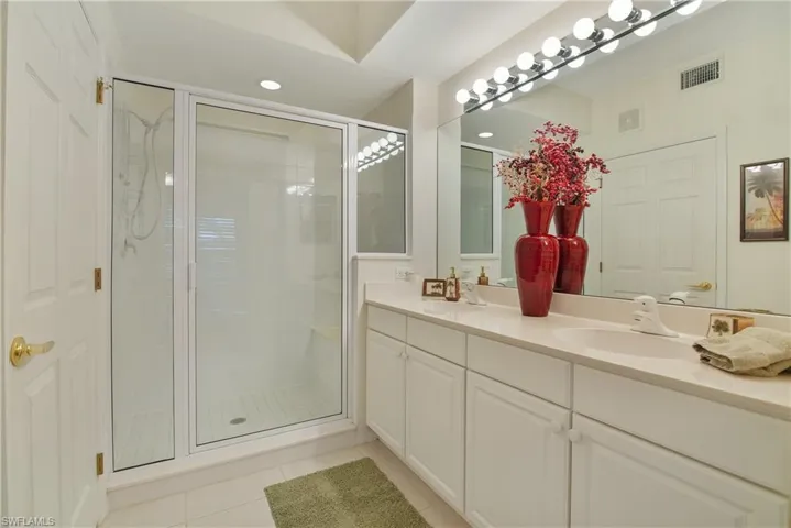 Bathroom with double vanity, a stall shower, light tile patterned floors, and recessed lighting
