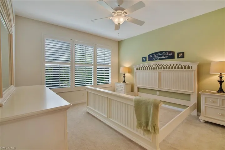 Carpeted bedroom with baseboards and a ceiling fan