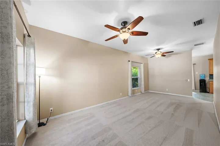 Unfurnished room featuring light colored carpet and a ceiling fan