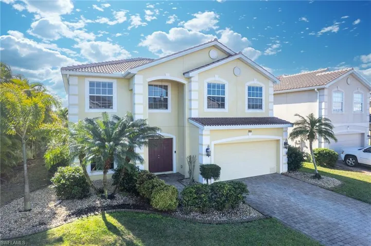 Mediterranean / spanish house with a tiled roof, an attached garage, decorative driveway, and stucco siding