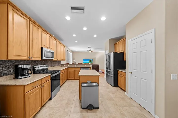 Kitchen with appliances with stainless steel finishes, recessed lighting, a peninsula, light tile patterned floors, and open floor plan