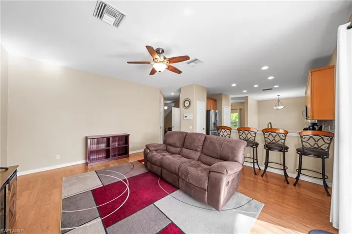 Living area with recessed lighting, a ceiling fan, and light wood-style floors