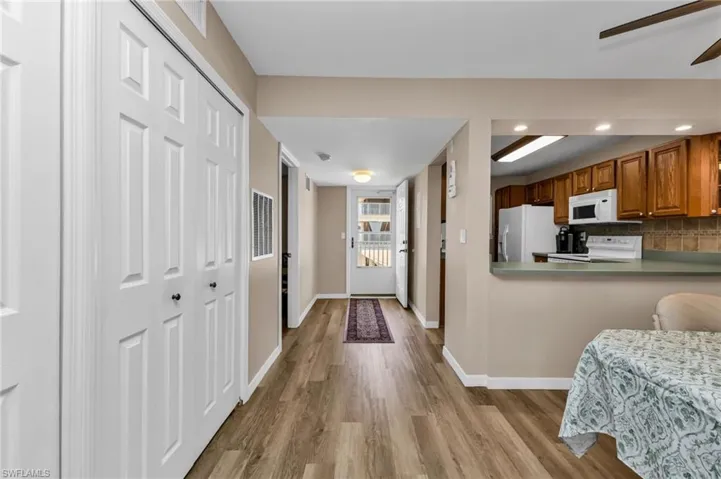 Kitchen with wood finish cabinetry, white appliances, ceiling fan, light wood finished floors, and recessed lighting