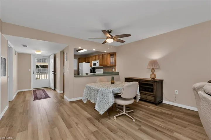 Dining area with a ceiling fan and light wood-type flooring