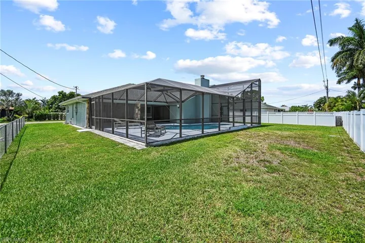 Spacious backyard with a screened pool enclosure and concrete pool deck