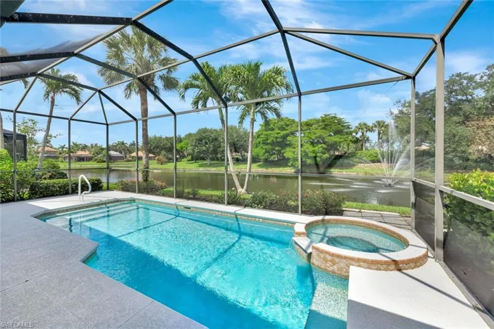 View of pool featuring a water view, a pool with connected hot tub, and a lanai