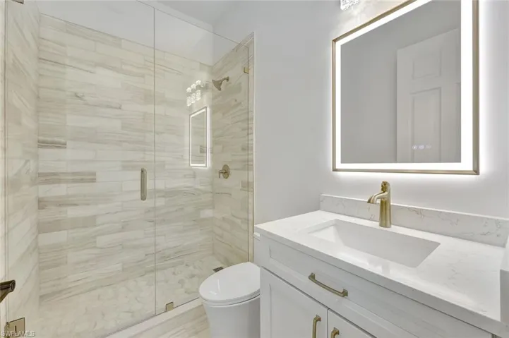 Bathroom with vanity and marble shower
