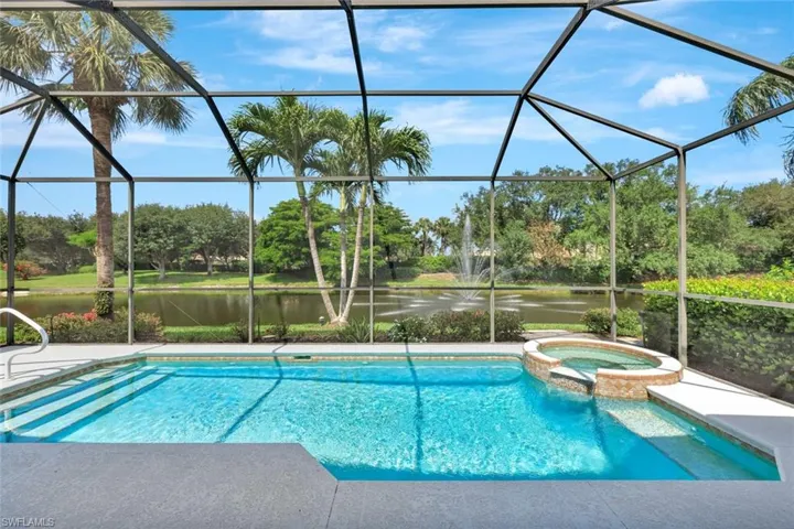 Western view of lanai, swimming pool, hot tub, palms and landscaping