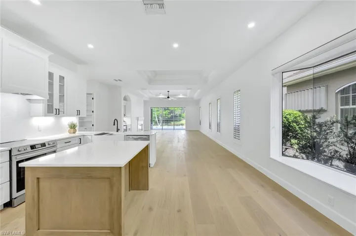Kitchen with new stainless steel appliances, open floor plan, a peninsula, a ceiling fan, and light countertops