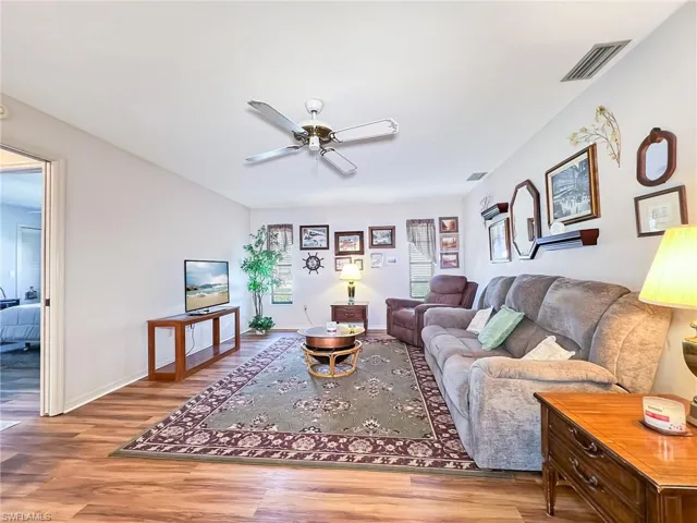 Living room featuring ceiling fan and hardwood / wood-style flooring