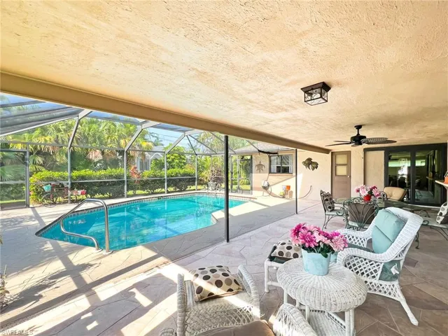 View of swimming pool featuring ceiling fan, a lanai, and a patio