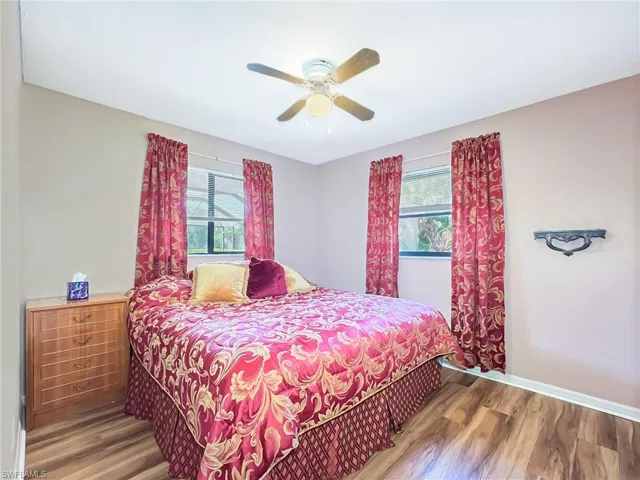 Bedroom with ceiling fan, wood-type flooring, and multiple windows