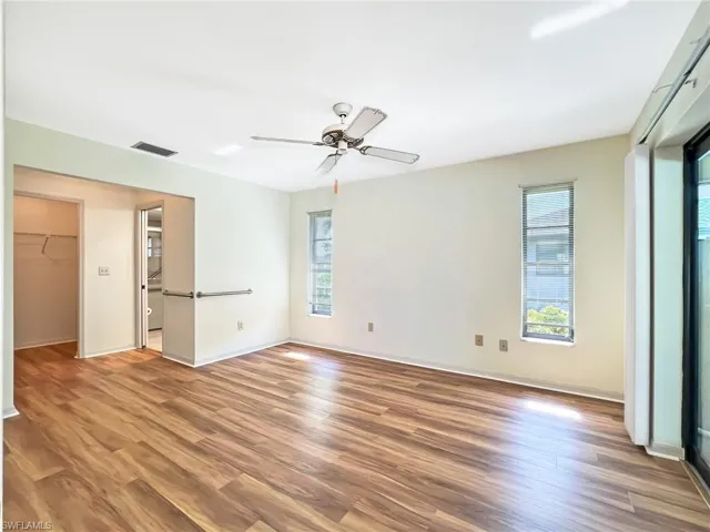 Unfurnished bedroom featuring multiple windows, ceiling fan, and wood-type flooring