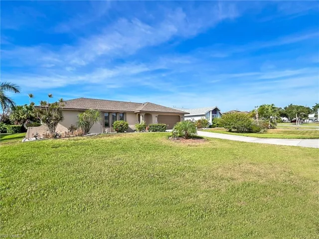 Ranch-style home featuring a front lawn and a garage