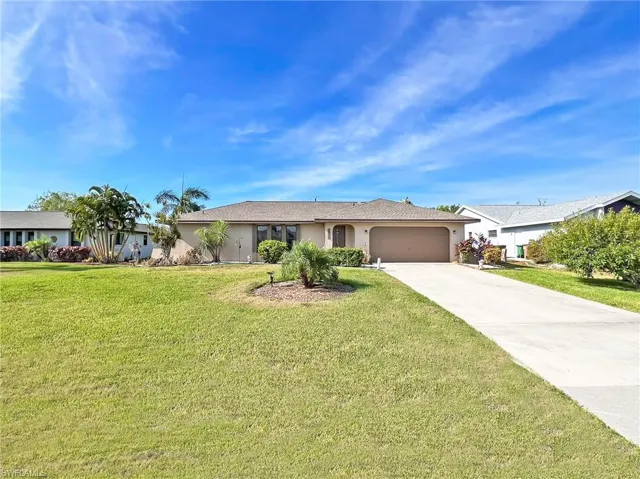 Single story home featuring a garage and a front yard