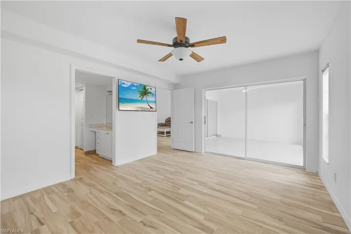 Unfurnished bedroom with light wood-type flooring, ceiling fan, a closet, and ensuite bathroom