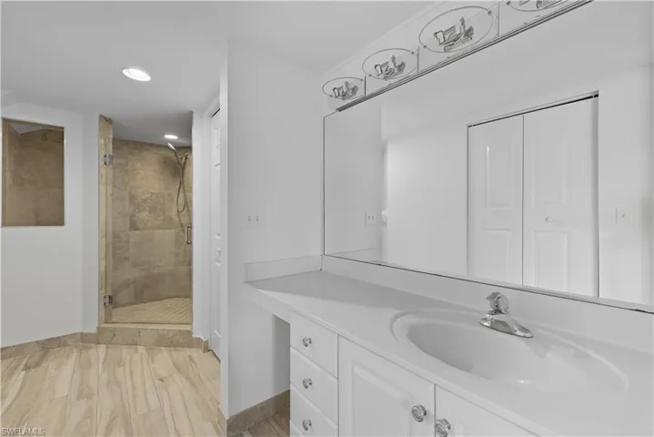 Full bathroom featuring a stall shower, vanity, recessed lighting, light wood-style floors, and a closet
