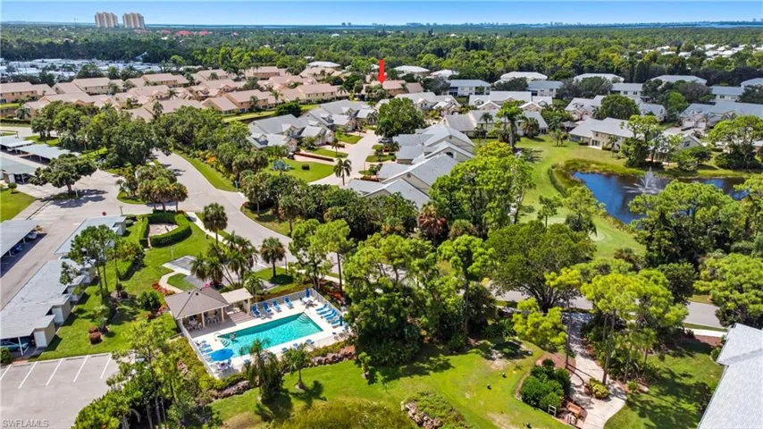 Aerial perspective of suburban area featuring a pool and a large body of water