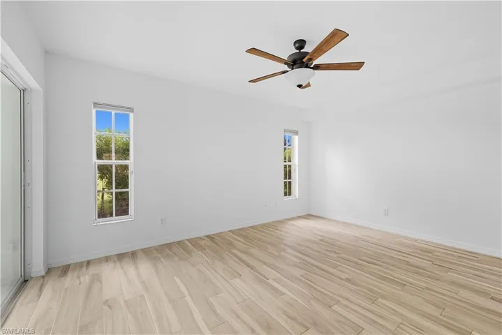 Spare room with light wood finished floors and a ceiling fan