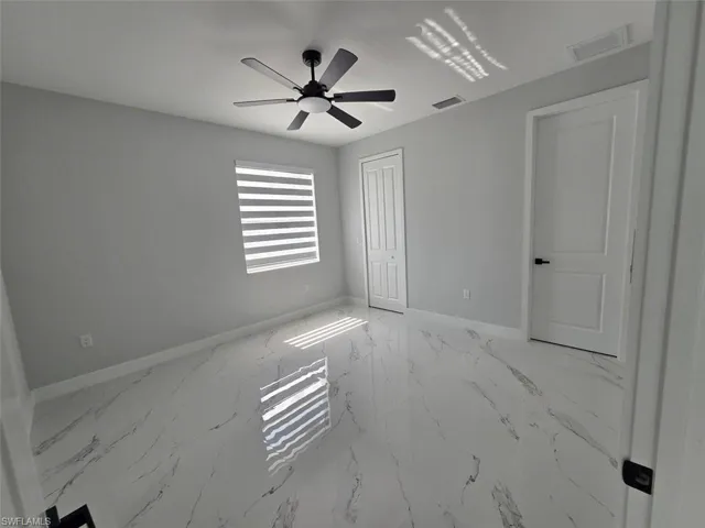 Room featuring large format marble-look tile flooring and light gray walls