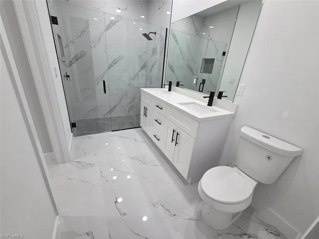 Bathroom featuring a double vanity with white cabinetry and black hardware