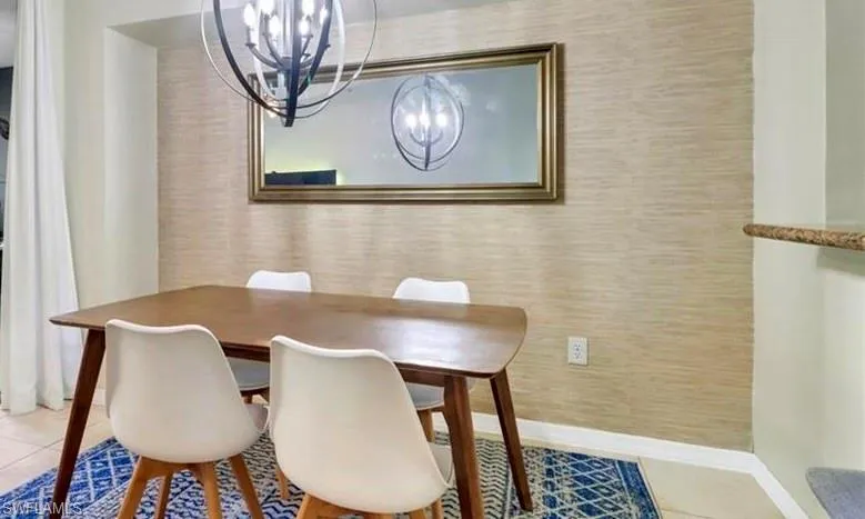 Dining space featuring baseboards and a chandelier