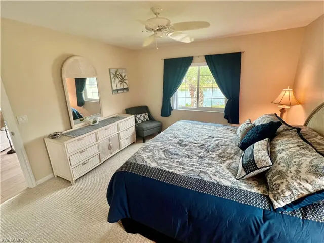Bedroom with baseboards, light carpet, and ceiling fan