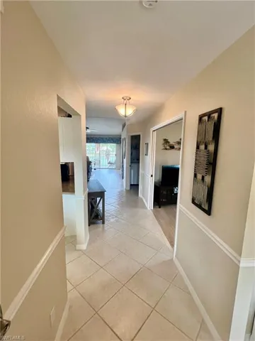 Corridor with light tile patterned floors and baseboards