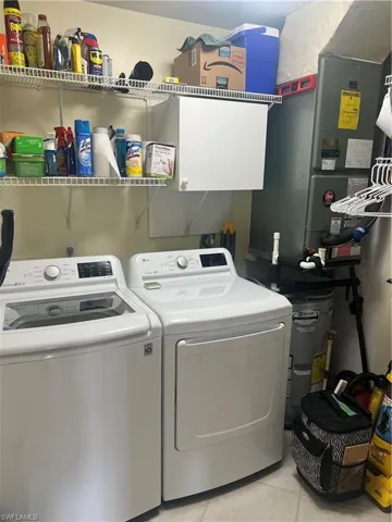 Washroom featuring light tile patterned flooring and washer and clothes dryer