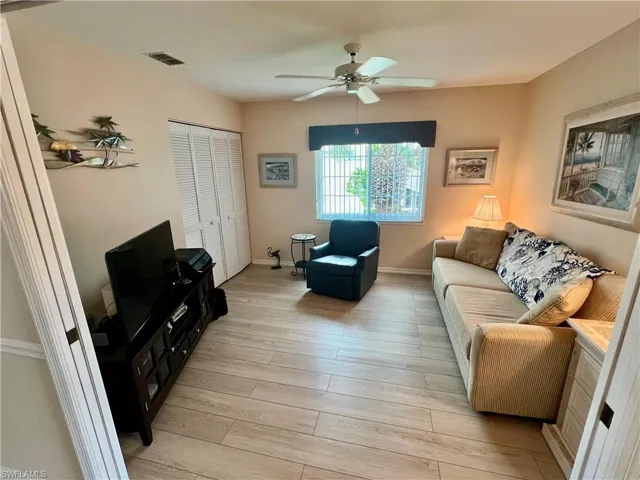 Living area featuring baseboards, a ceiling fan, visible vents, and light wood-type flooring
